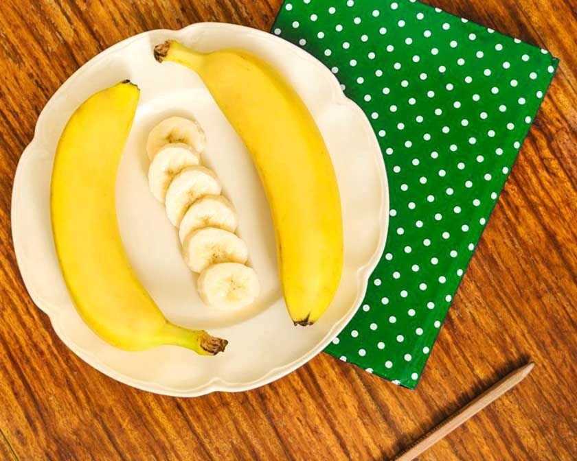 2 bananas and some slices of them on a plate which can be part of the best way to freeze bananas