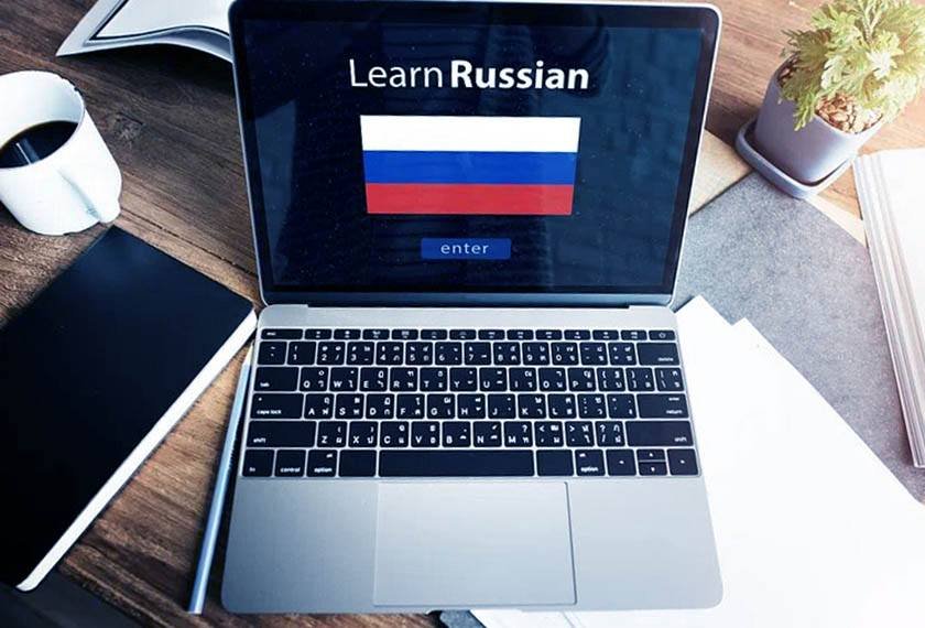 A desk on which there is a laptop on which he writes learn Russian, as this can be the best way to learn Russian