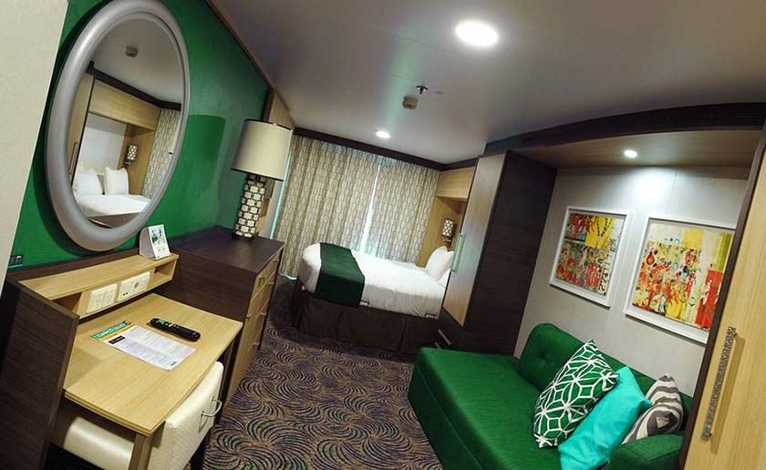 Luxury ship cabin with bed, sofa, coffee table, TV and mirror