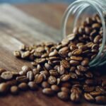 Close-up photo of scattered coffee beans from a jar which can be the best way to store coffee beans