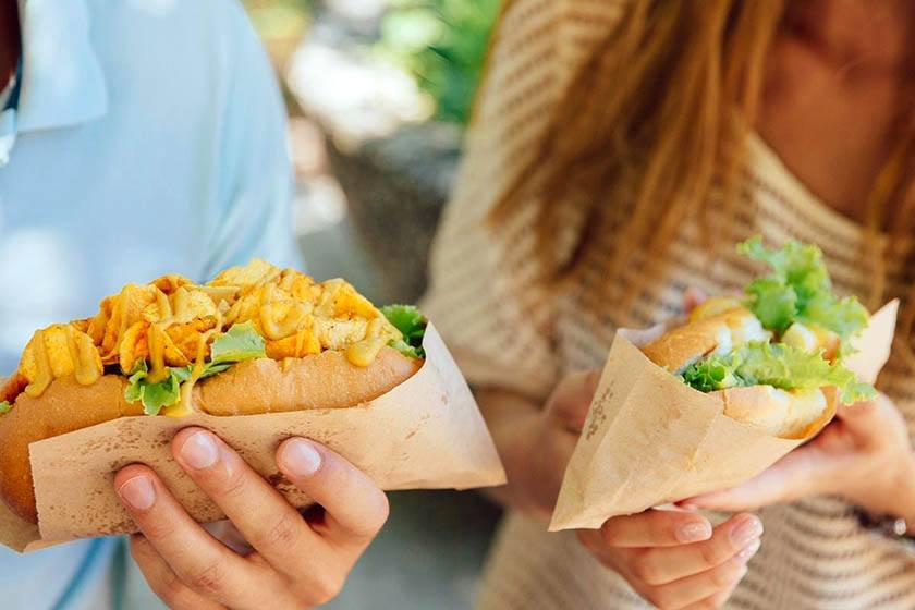 Man and woman holding sandwiches