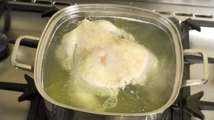 Chicken in boiling water which is part of the process for the best way to boil chicken