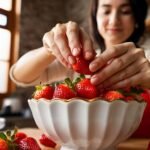 A woman performs the best way to clean strawberries