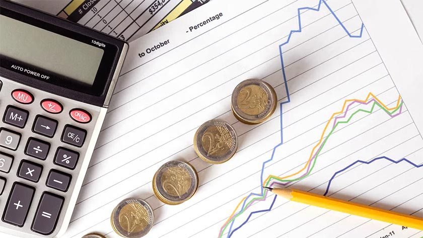 A sheet of paper with coins, a calculator and a pen