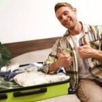 A happy man shows the best way to pack a suitcase