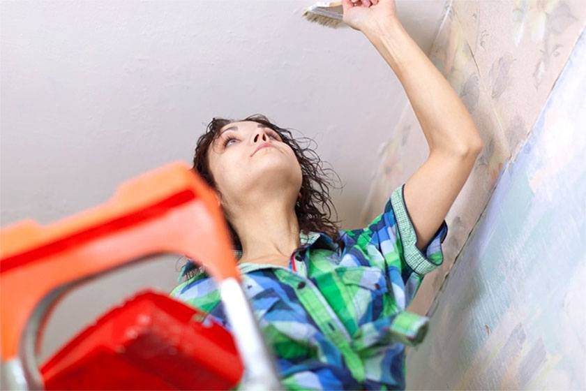 A woman performs the best way to paint a ceiling