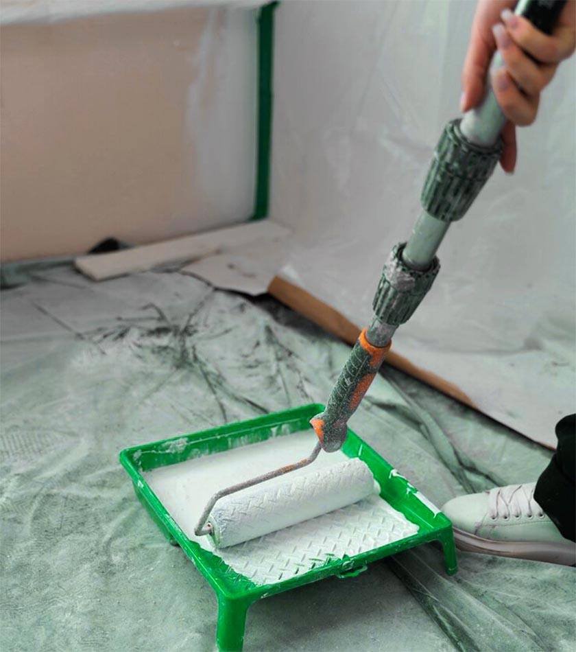 A woman holds a paint machete with an extension and melts it into a paint pan