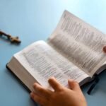 Picture of hands holding the bible and a Chain with a cross, which is the best way to read the bible