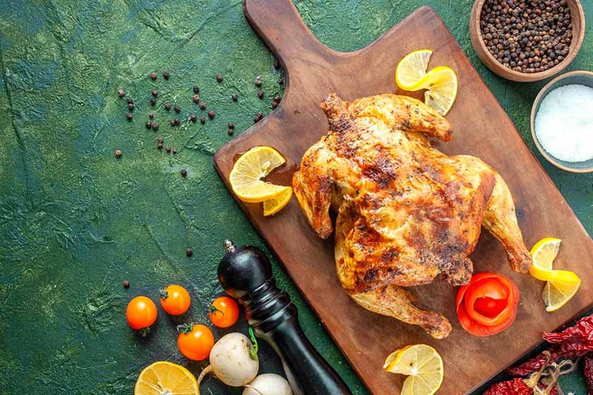 Chicken on a wooden board with spices around it is the best way to season chicken