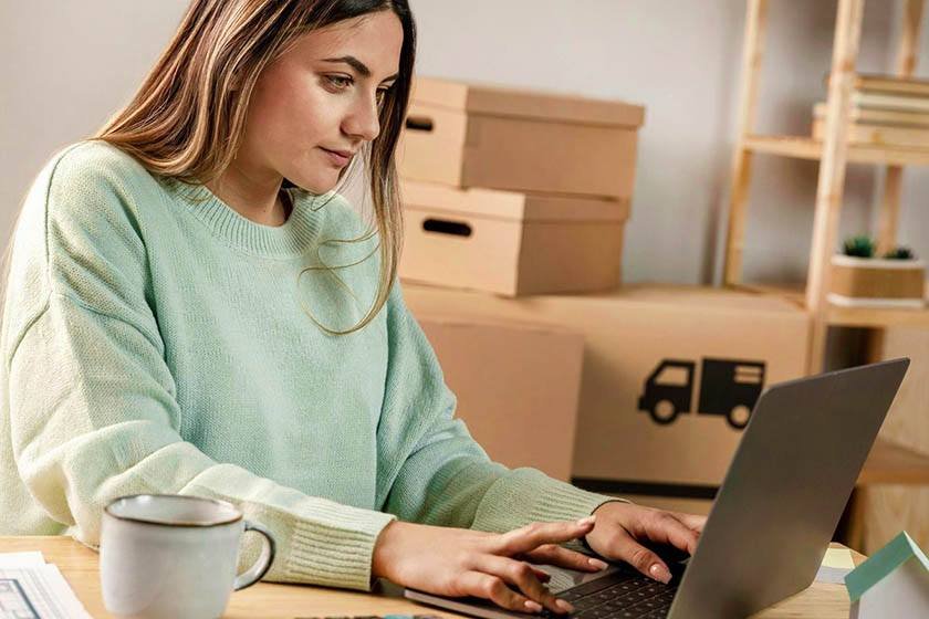 Woman working on her laptop ready to sell things and behind her online