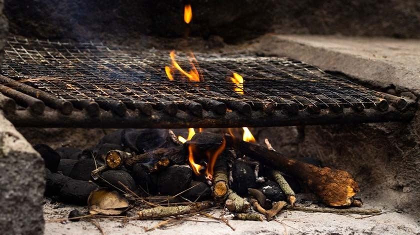 A metal grill with a fire under it