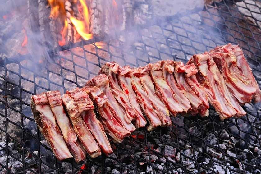 Fresh ribs placed on the grill with a light fire