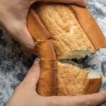 Hands break bread which can be part of the process of what it is the best way to store bread