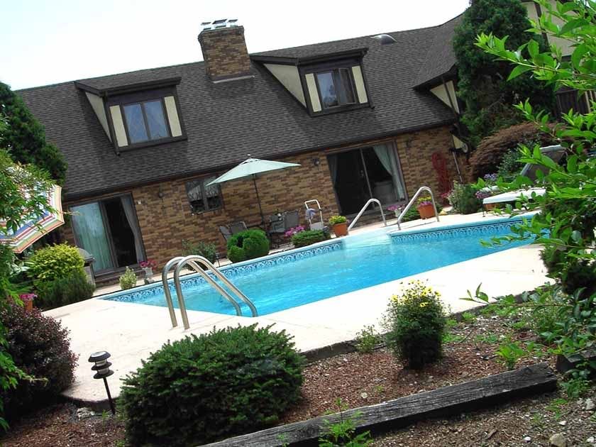 A house with a pool and vegetation which is part of the best way to finance a pool