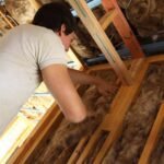 A man performs the best way to insulate attic