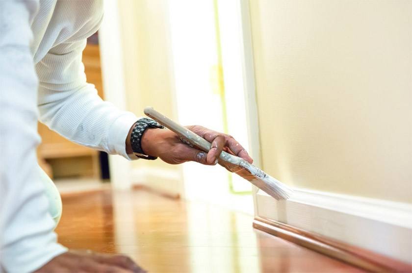 A man performs the best way to paint baseboards