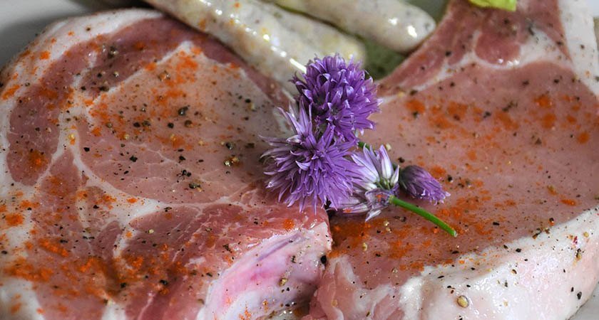 Raw marinated pork chop with a little flower on it