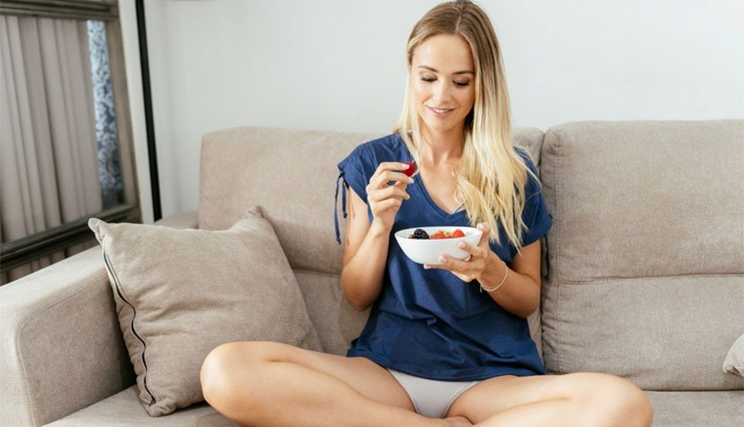 A blonde woman on a sofa will try berries