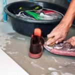 A man performs the best way to wash sneakers