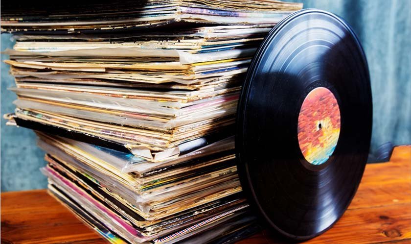 An old vinyl record propped up against other vinyl records