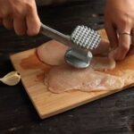 A man performs the best way to tenderize steak with hammer