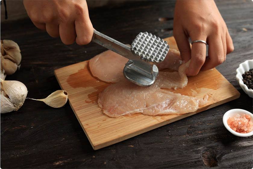 A man performs the best way to tenderize steak with hammer