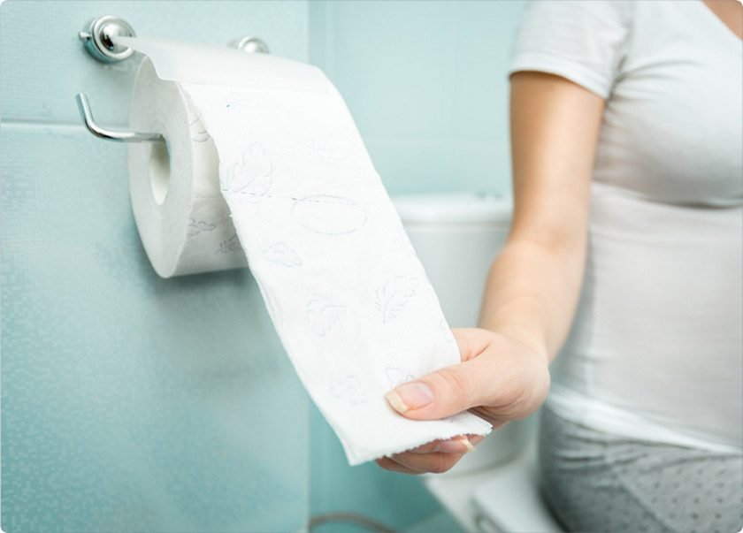 A woman is going to use toilet paper