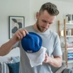 Man performs the best way to was a baseball cap with a towel