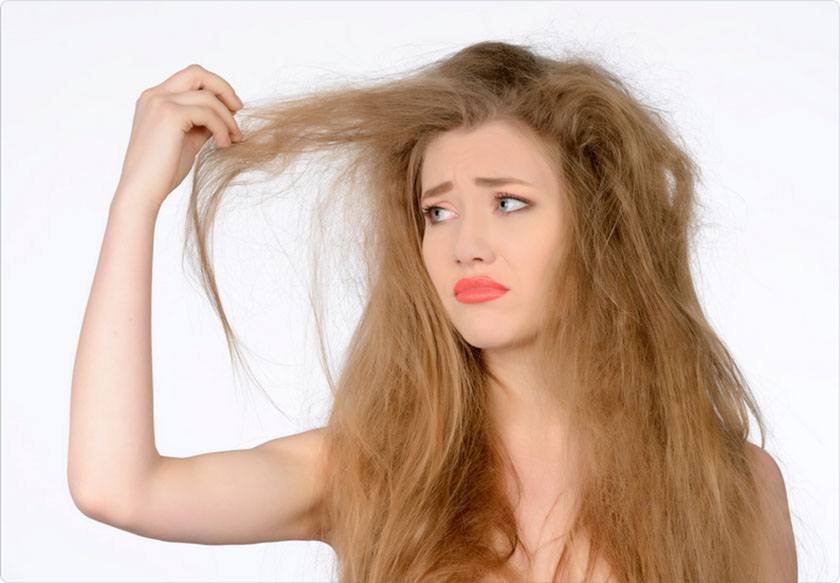 Sad woman touches her dry hair