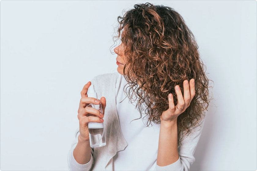 A woman applies water to moisture her hair before going to bed